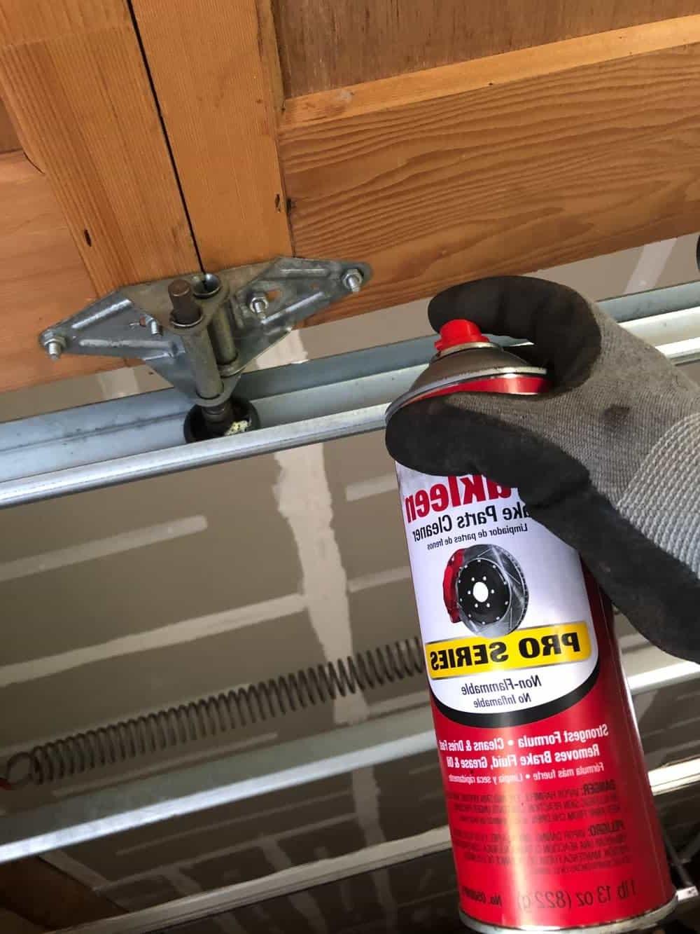 spraying parts cleaner on door tracks